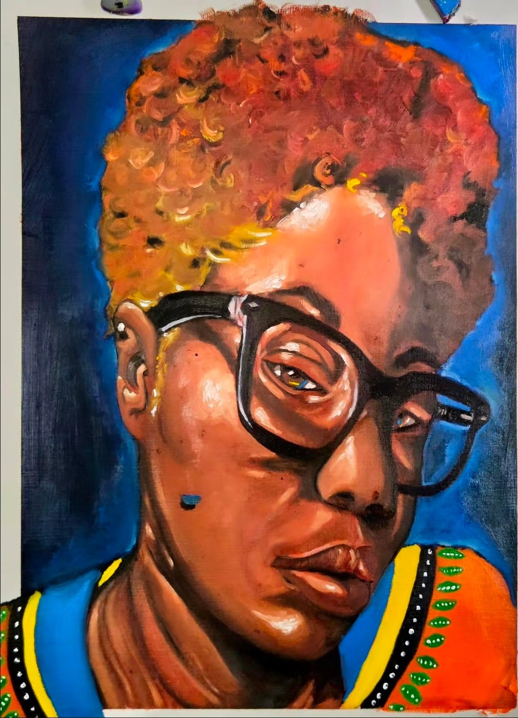 Portrait of a person with a curly afro and glasses against blue
