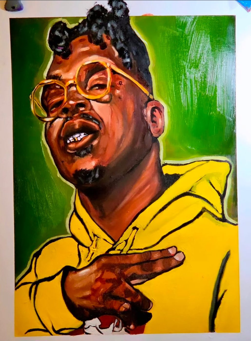 Portrait in a yellow hoodie, green background